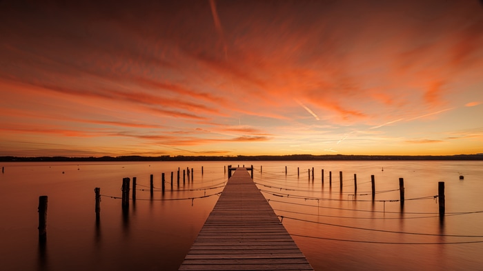 4K pier on a lake at sunset with orange sky