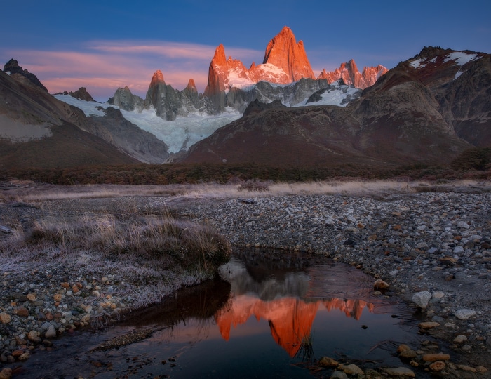 Fitz Roy mountain range reflecting in a stream at sunset