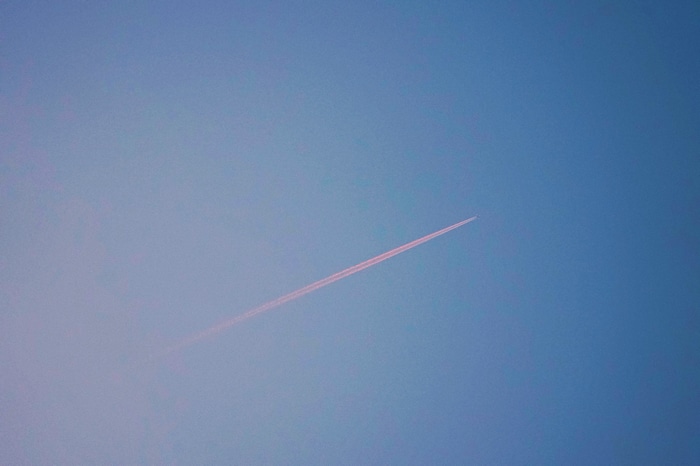 4K airplane contrail in blue sky