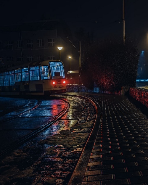Tram on wet tracks at night