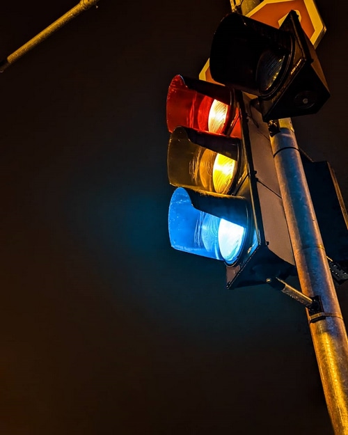 Traffic light with red, yellow, and blue lights at night