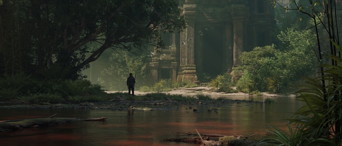 Person standing by ancient ruins near a river