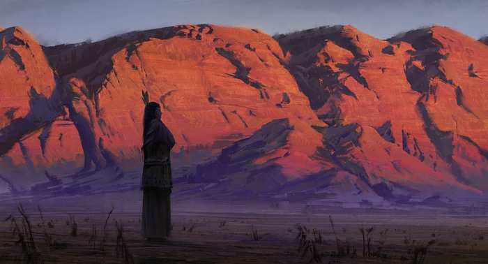 Native American woman stands before sunlit mountains