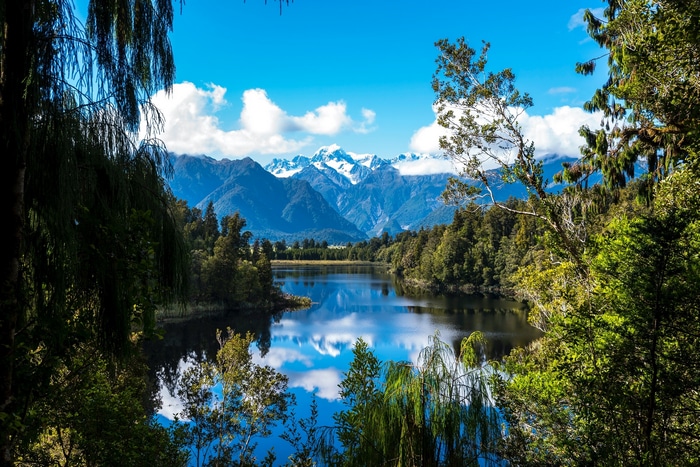 Lake reflection of snow-capped mountains and trees