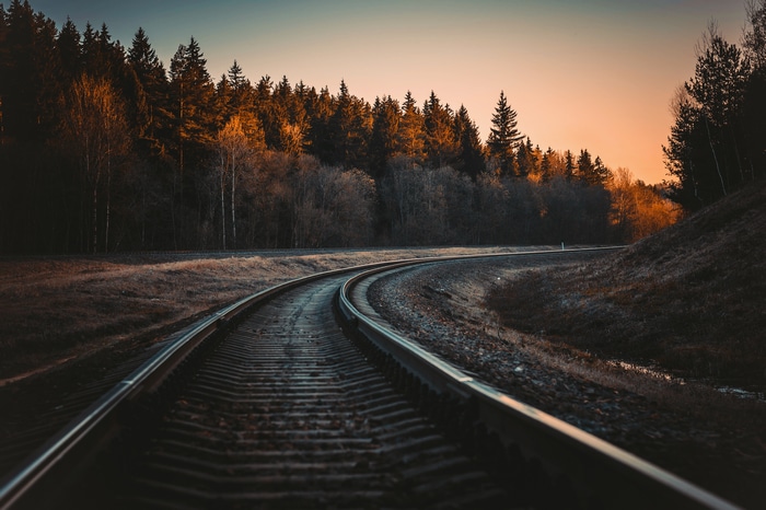 4K railway in fall forest at sunset