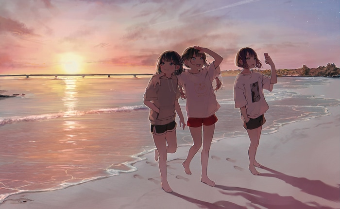 Three girls walk on a beach at sunset