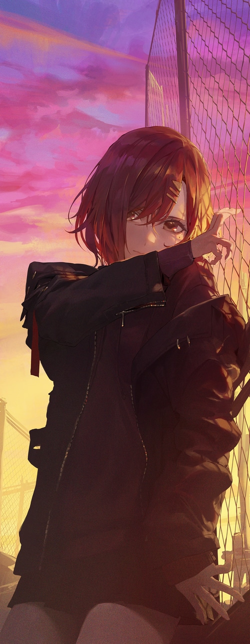 Girl in black jacket by chain-link fence at sunset