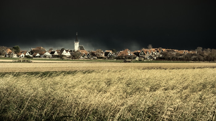 Village in the Netherlands with a field and dark sky