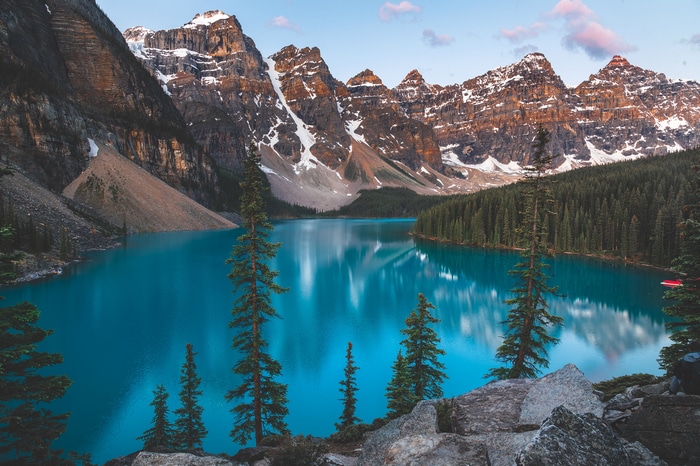 Moraine Lake with snow-capped mountains and pine forest