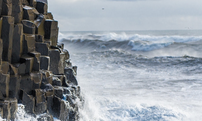 Basalt columns on the coast with crashing waves
