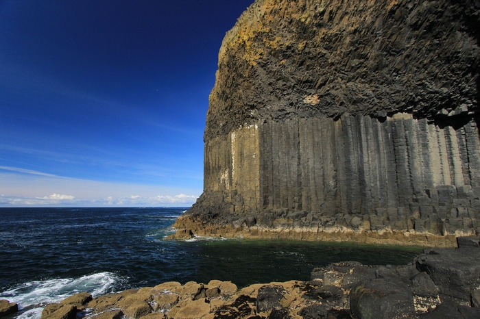Basalt columns on the coast under a blue sky