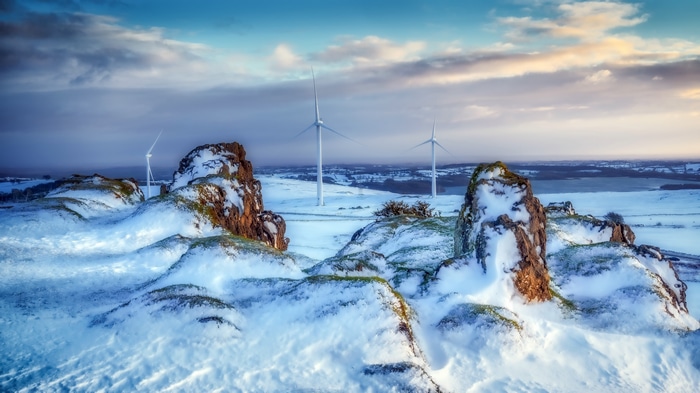 Winter landscape with wind turbines and snow-covered rocks