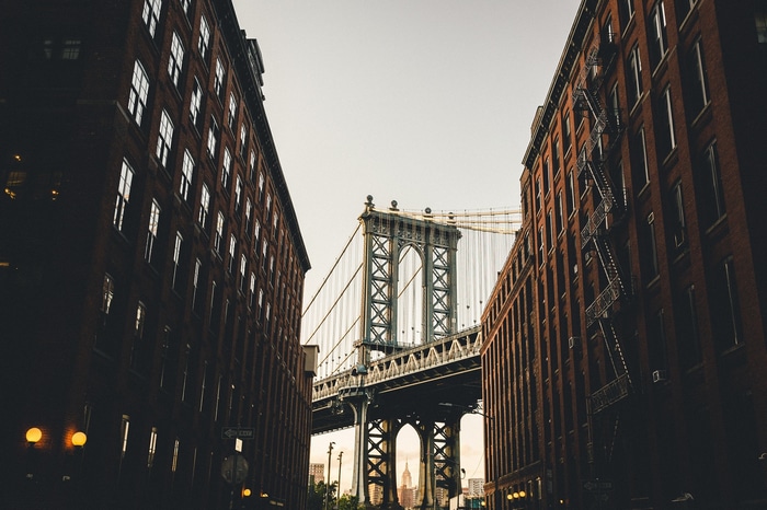 Manhattan Bridge viewed between brick buildings in New York City