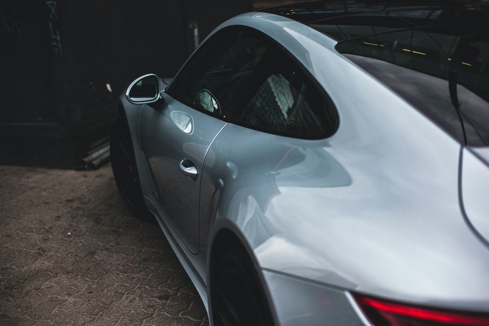 Silver Porsche 911 parked on cobblestone