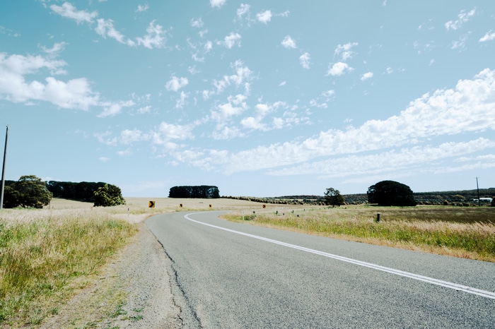 Road through grassy fields in Australia