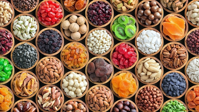 Collage of various nuts, dried fruits, and seeds in bowls