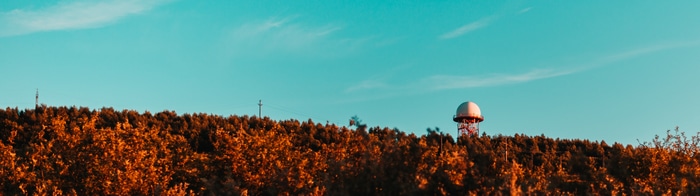 Ultrawide view of autumn trees and a radar dome