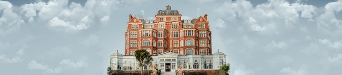 4K ultrawide view of a grand brick building against a cloudy sky