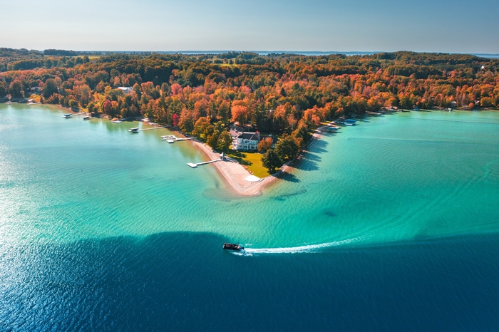 Aerial view of a house on a lake during fall