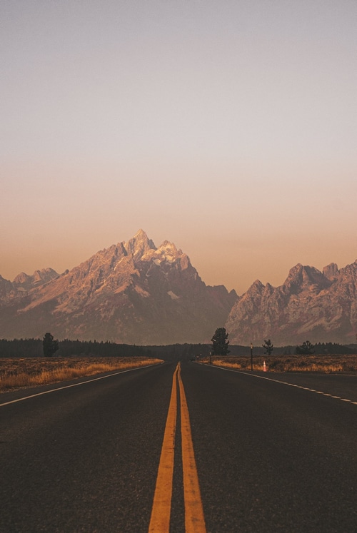 Road leading to mountains at sunset