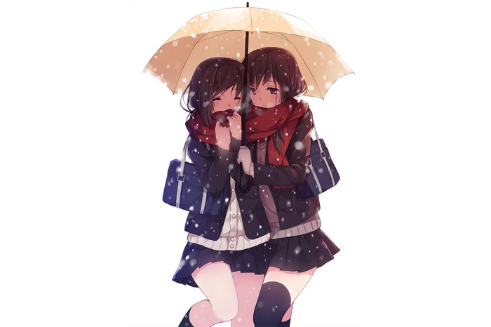 Two girls sharing an umbrella in the snow
