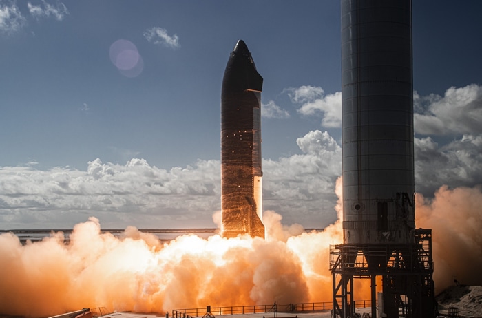 SpaceX Starship rocket launches with massive orange smoke plume