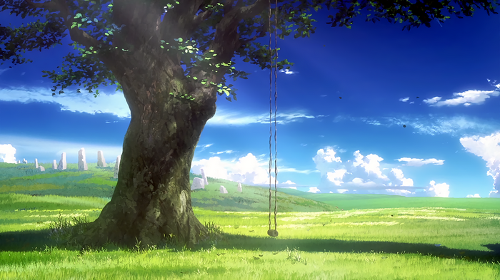 A large tree with a swing in a grassy field under a blue sky