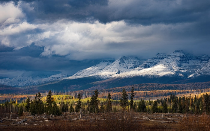 Snow-capped Rocky Mountains under stormy clouds