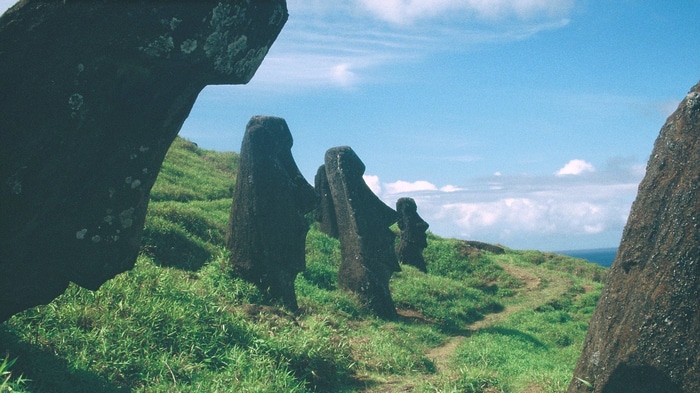Moai statues on Easter Island with green grass and blue sky