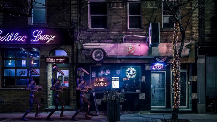 Robots walking past Cadillac Lounge with a car on the facade