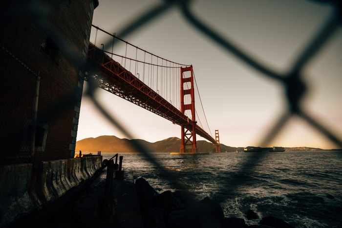 Golden Gate Bridge seen through a fence at sunset