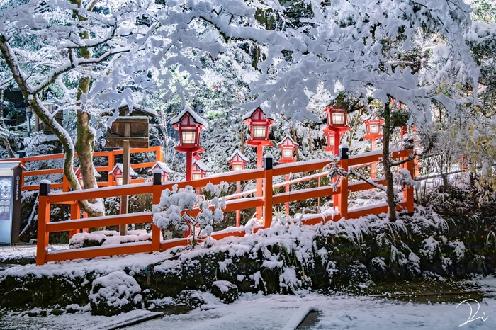 Snowy Japanese temple with red lanterns