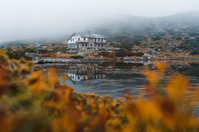 Mountain cabin by a lake in the mist