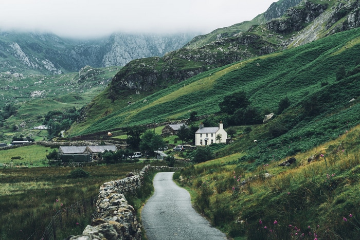 A winding road leads to a village in a green mountain valley