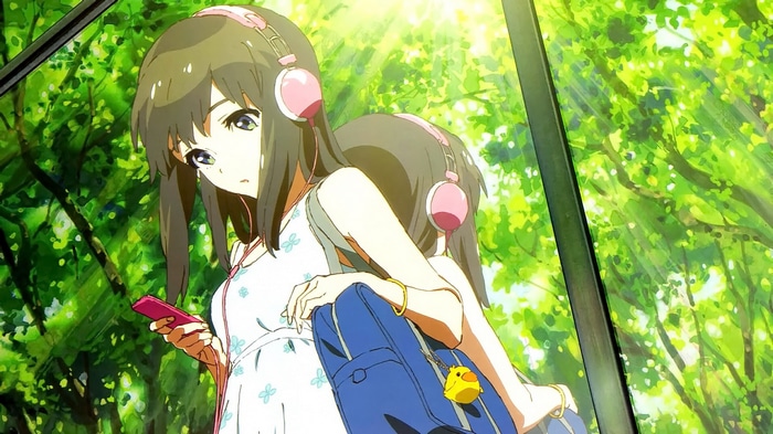Girl with headphones and phone in a green forest
