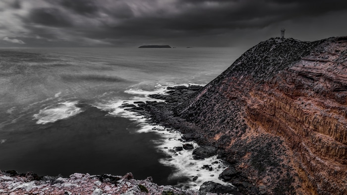Lighthouse on a rocky cliff overlooking the sea