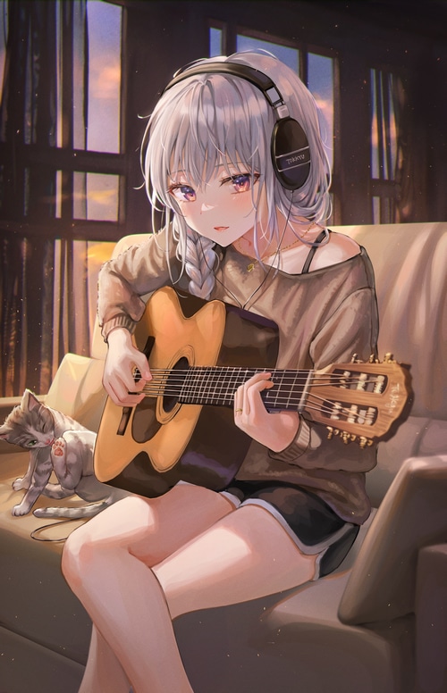 Girl with headphones playing guitar with cat
