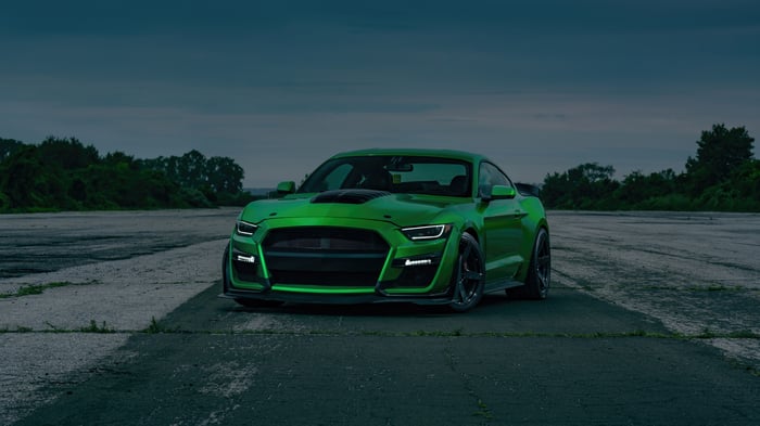Green Ford Mustang parked on asphalt