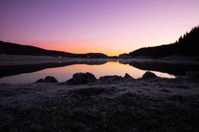 Lake reflecting purple and orange sunset sky