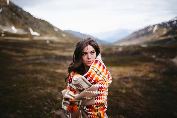Woman wrapped in a blanket in a mountain landscape