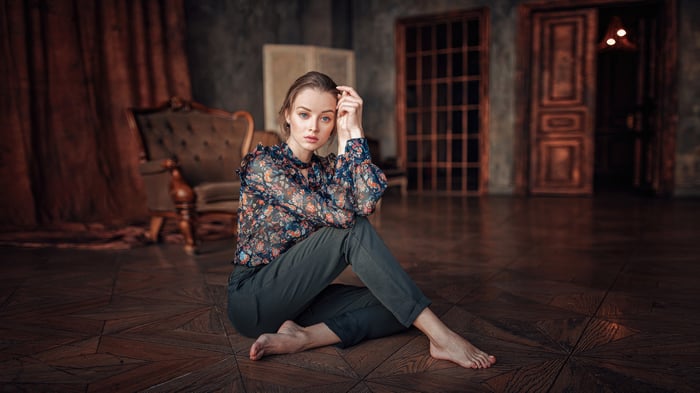Girl in a floral shirt sitting on the floor