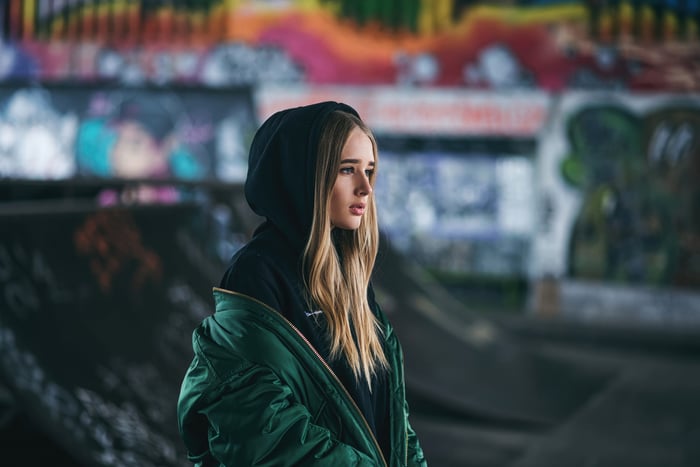 Girl in a black hoodie and green jacket