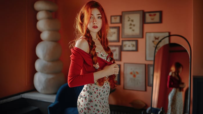 Redhead girl with braided hair in a red cardigan