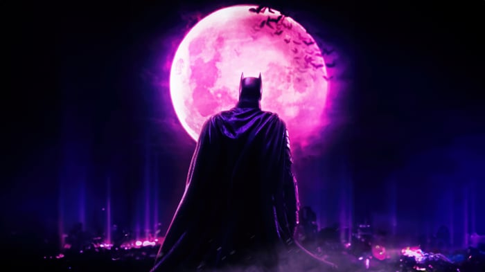 Batman in front of a pink moon with bats