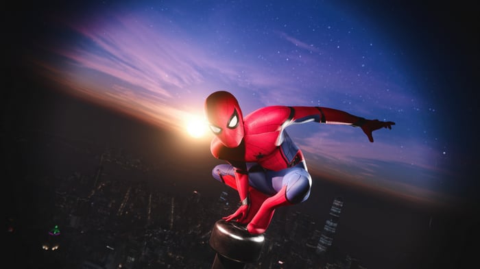 Spider-Man crouches on a building at sunset