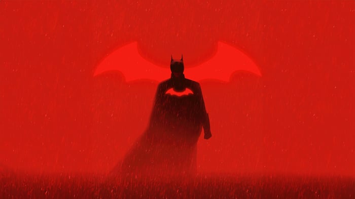Batman Silhouette with Bat Symbol in Red Rain