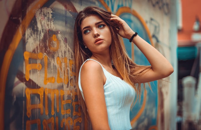 Tanned Girl With Blue Eyes Posing Against Graffiti Wall