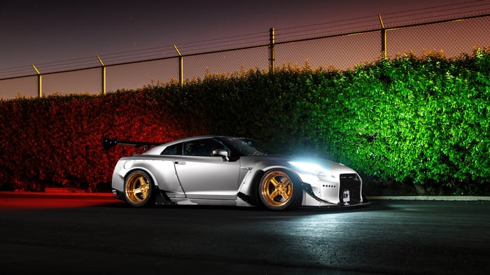 Silver Nissan GTR with gold wheels at night