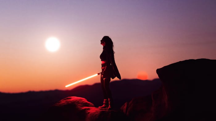 Rey Star Wars Cosplay Girl with Lightsaber at Sunset