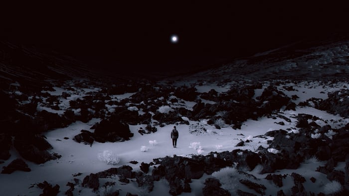 Person walking in dark Iceland landscape under moonlight